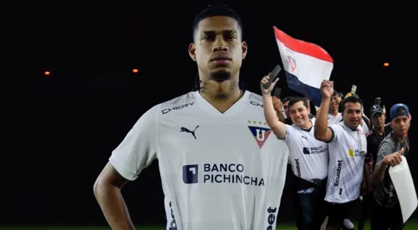 Marco Angulo con la camiseta de LDU, al lado los hinchas del conjunto albo alentando. FOTO: Primicias